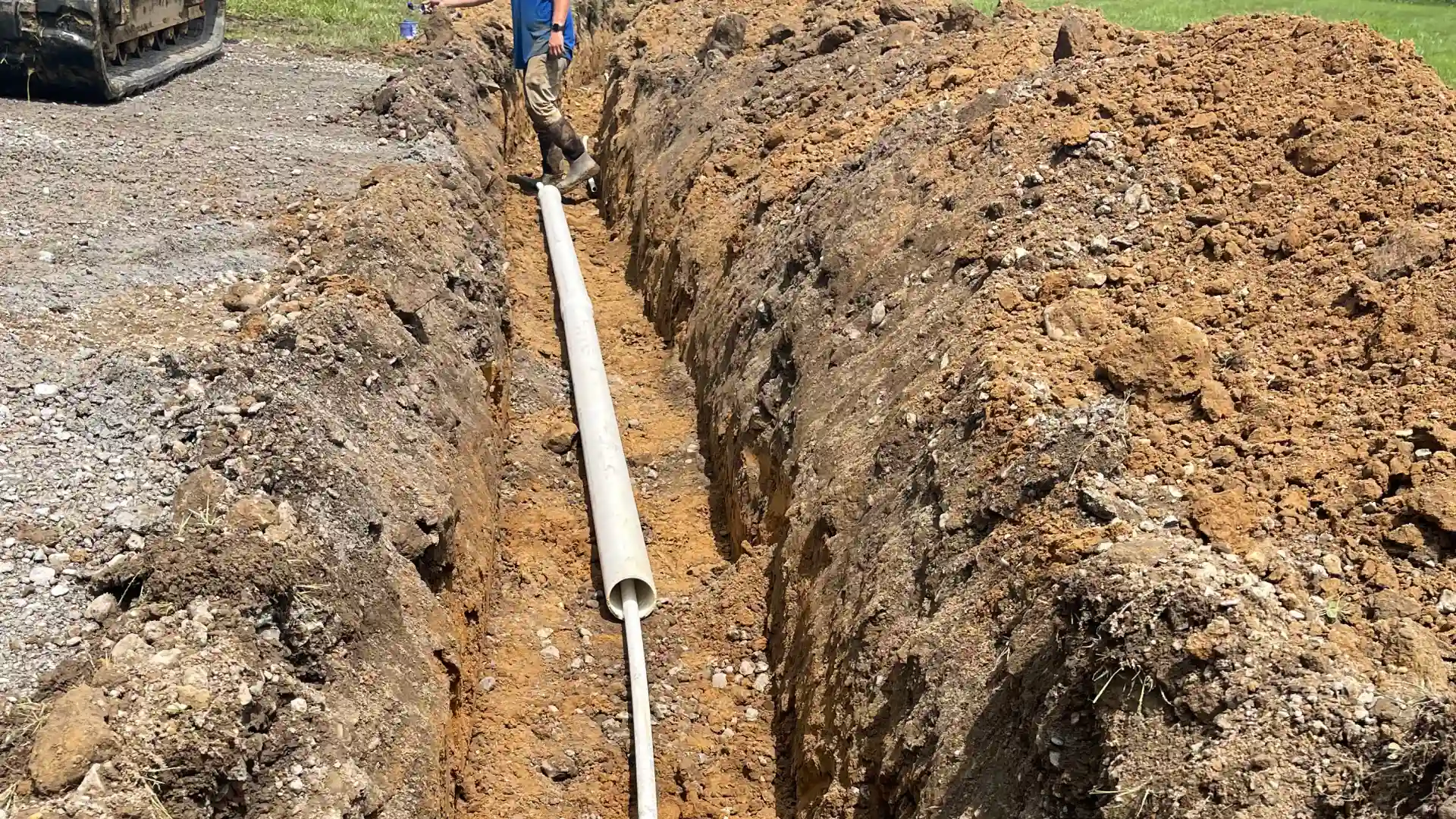 trench and white pipe in ground